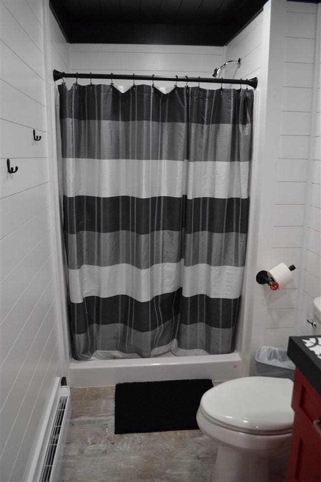 bathroom with curtained shower and toilet