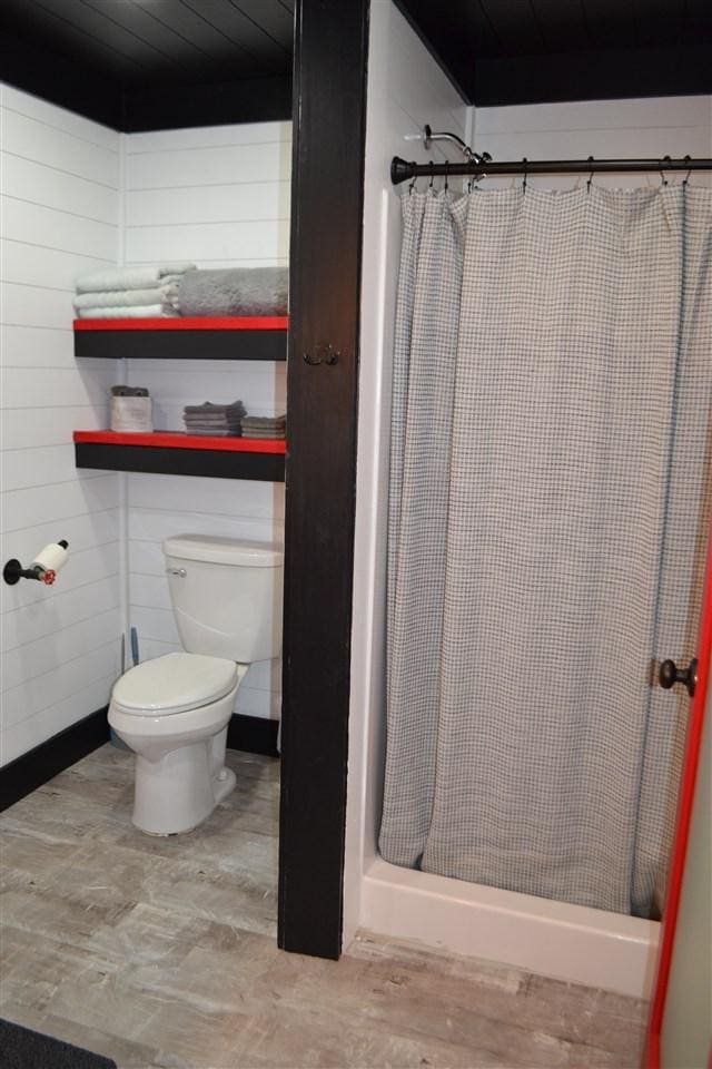 bathroom with curtained shower and toilet