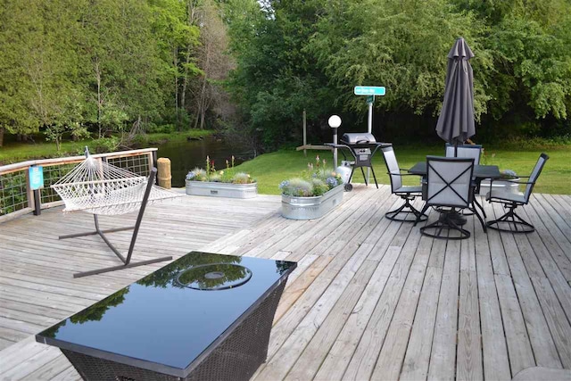 wooden terrace featuring a lawn