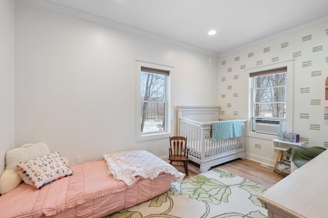 bedroom with light wood finished floors, multiple windows, cooling unit, and crown molding