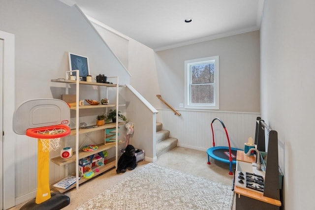 playroom with carpet floors, wainscoting, and crown molding