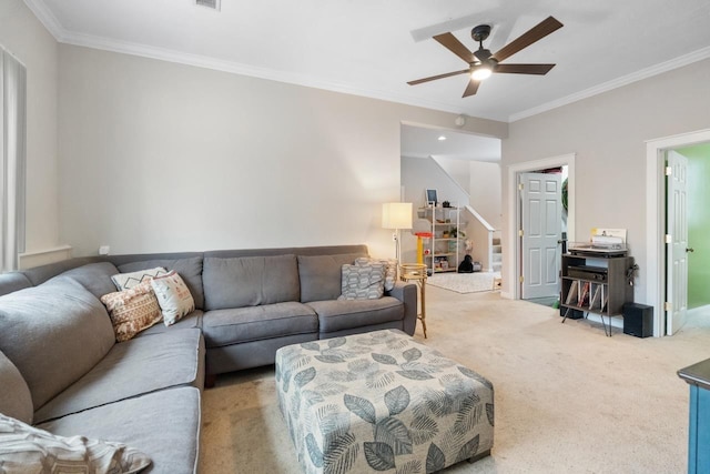 carpeted living room with ceiling fan, stairway, and ornamental molding