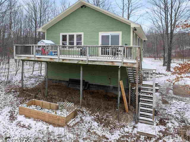 snow covered property with stairs and a deck