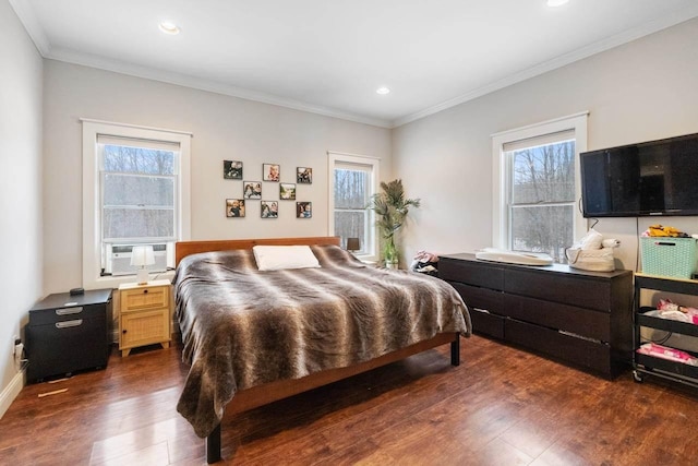 bedroom featuring cooling unit, multiple windows, ornamental molding, and dark wood-type flooring