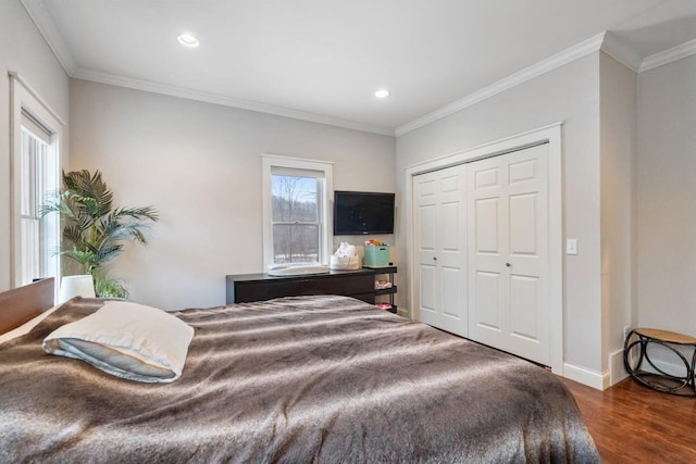 bedroom featuring dark wood-style floors, ornamental molding, a closet, and recessed lighting