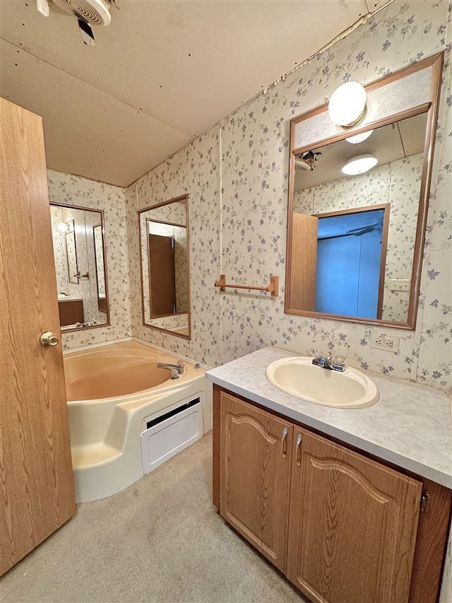 bathroom featuring a washtub, vanity, and lofted ceiling