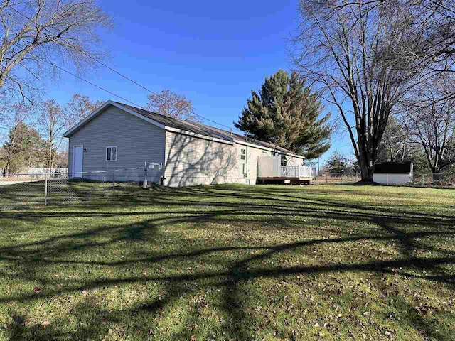 view of side of home with a yard and a deck