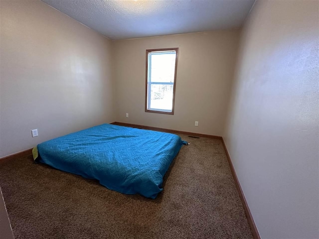 bedroom featuring carpet flooring and a textured ceiling