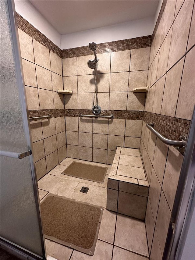 bathroom featuring tile patterned floors, tile walls, and tiled shower