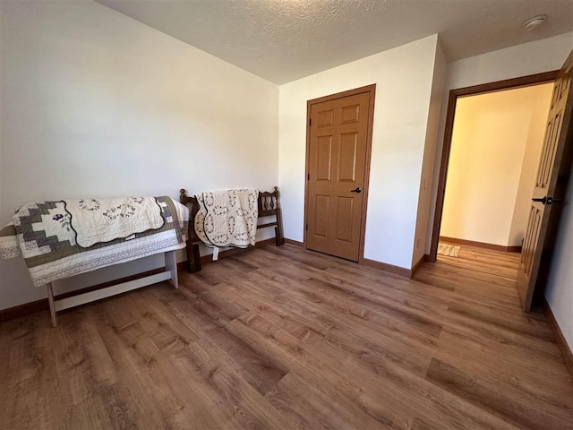 sitting room with hardwood / wood-style floors and a textured ceiling