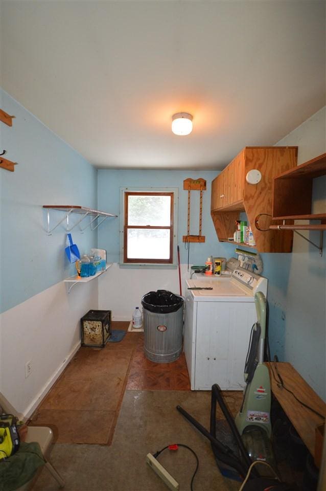 clothes washing area featuring washer and clothes dryer and cabinets