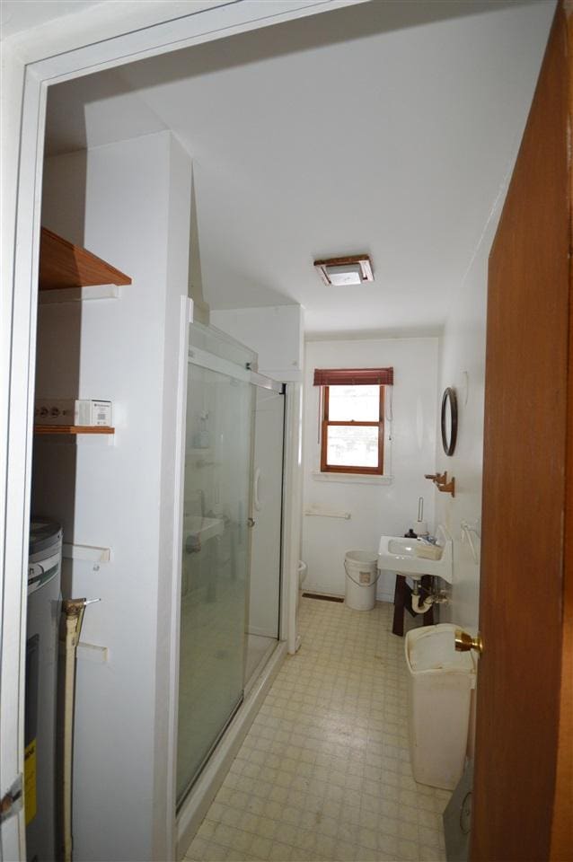 bathroom featuring a bidet, toilet, an enclosed shower, and sink