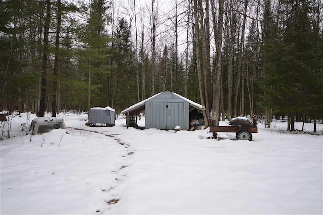 snowy yard featuring a storage unit