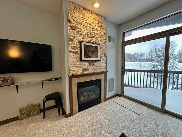 living room with a stone fireplace and carpet floors