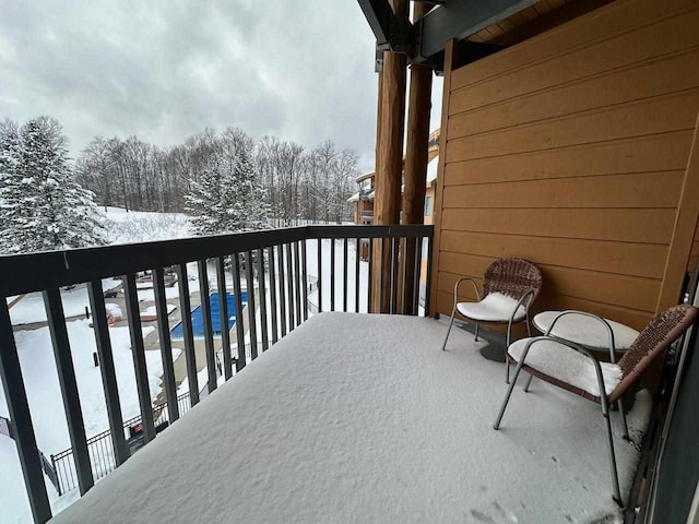 view of snow covered back of property