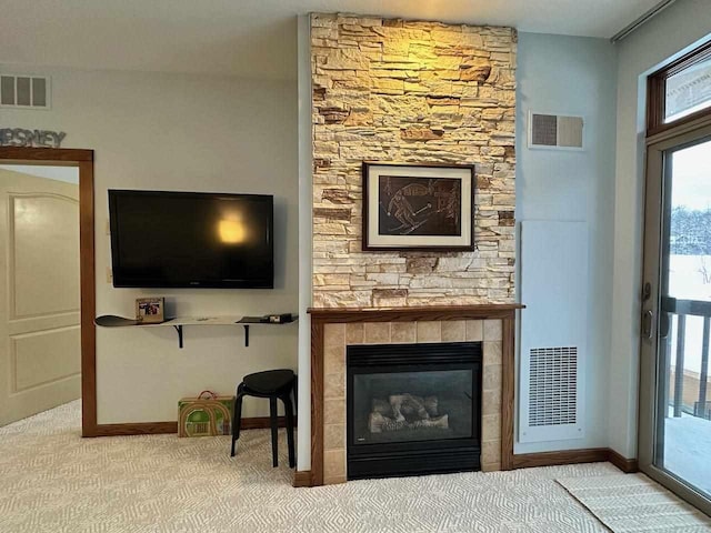 living room featuring carpet flooring and a stone fireplace