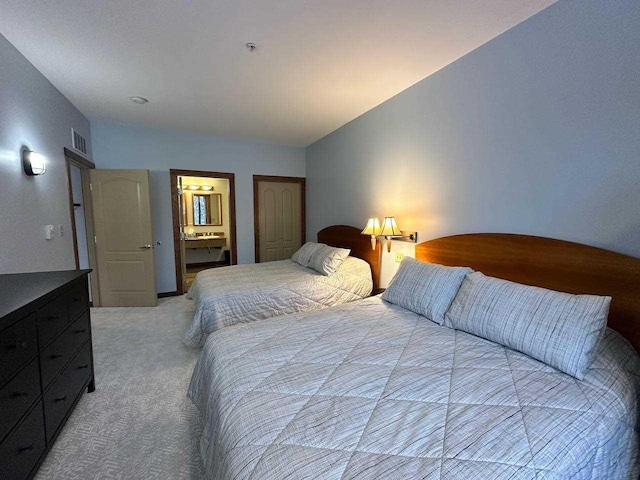 carpeted bedroom with connected bathroom and vaulted ceiling