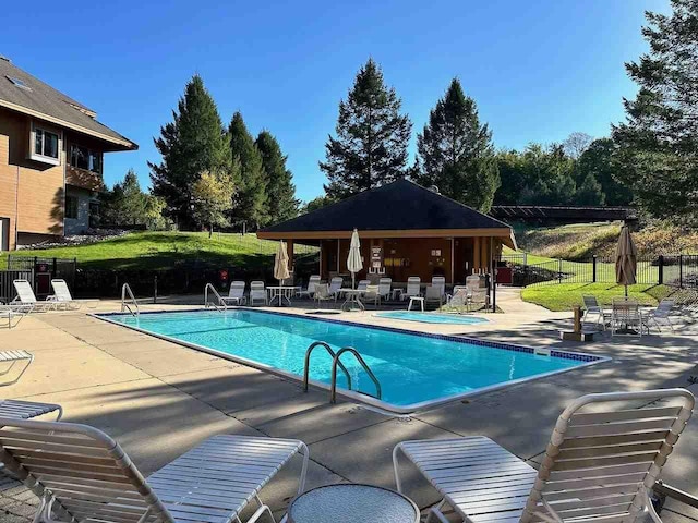 view of swimming pool featuring a yard and a patio