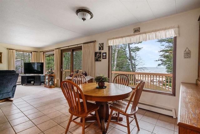 tiled dining room with a water view, a wealth of natural light, and a baseboard radiator