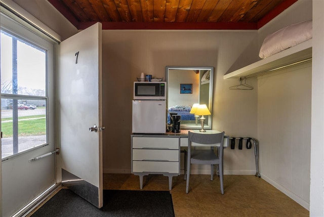 office area featuring carpet flooring, plenty of natural light, and wood ceiling