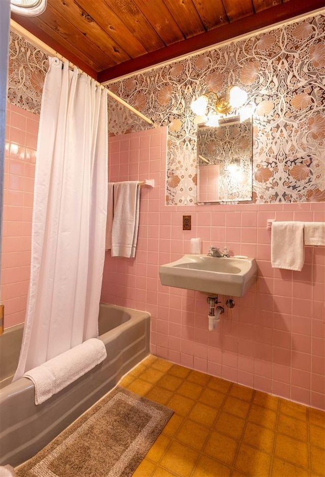 bathroom featuring shower / bath combo, wooden ceiling, sink, tile patterned flooring, and tile walls