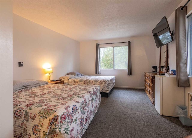 bedroom with a textured ceiling and dark carpet