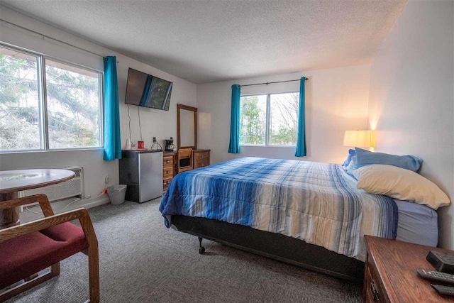 bedroom with carpet flooring, stainless steel fridge, and a textured ceiling