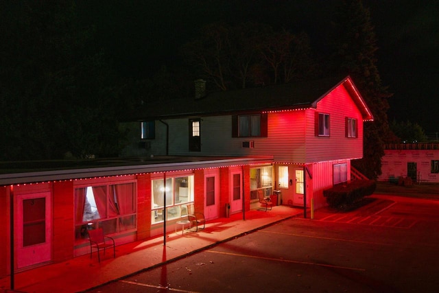 back house at twilight featuring a patio