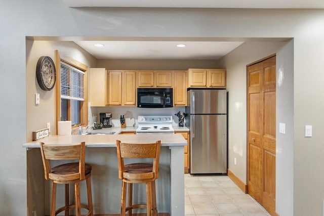 kitchen featuring kitchen peninsula, a kitchen breakfast bar, light brown cabinets, electric range, and stainless steel refrigerator