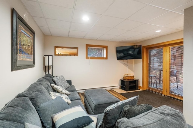 living room featuring a baseboard radiator and a drop ceiling