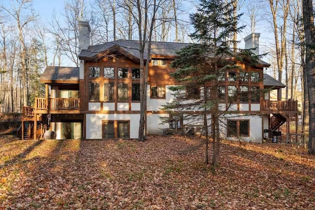 back of property with a sunroom and a deck