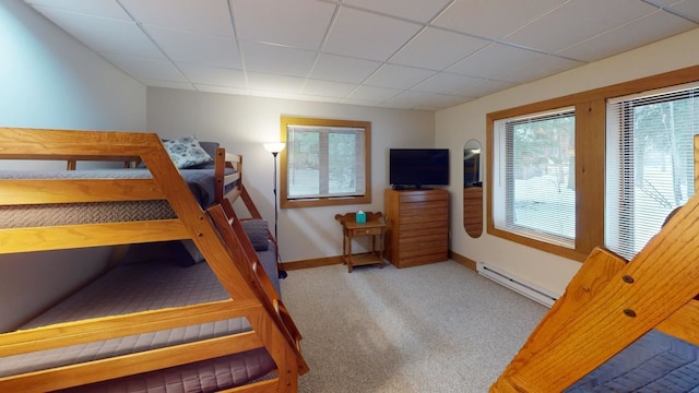 carpeted bedroom featuring a paneled ceiling and baseboard heating