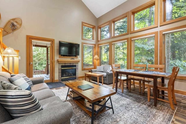 living room with a tile fireplace, hardwood / wood-style floors, and high vaulted ceiling