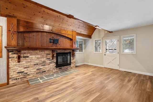 unfurnished living room with wooden walls, a fireplace, and wood-type flooring