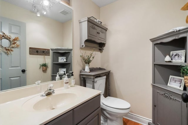 bathroom with hardwood / wood-style floors, vanity, and toilet