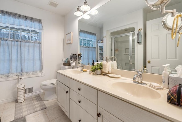 bathroom with tile patterned floors, a shower with door, vanity, and toilet