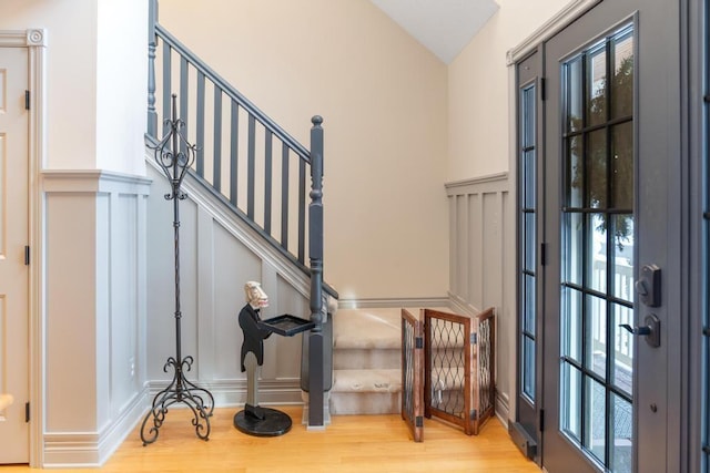 stairs featuring hardwood / wood-style flooring and lofted ceiling