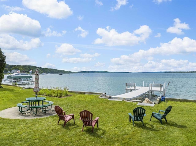 dock area featuring a water view and a lawn