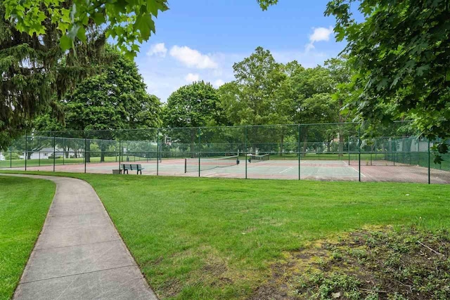 view of sport court with a lawn