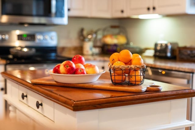 interior details featuring white cabinets and appliances with stainless steel finishes