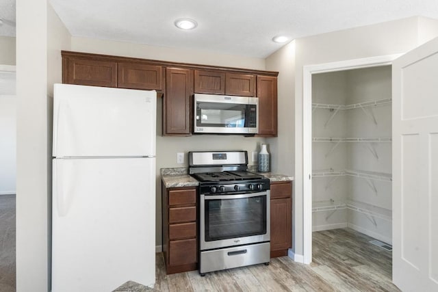 kitchen featuring stainless steel appliances and light hardwood / wood-style flooring