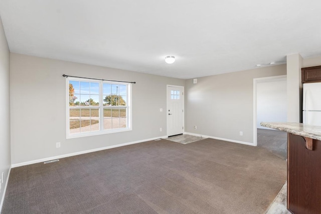 unfurnished living room featuring dark carpet