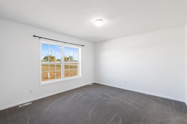 unfurnished room featuring dark carpet