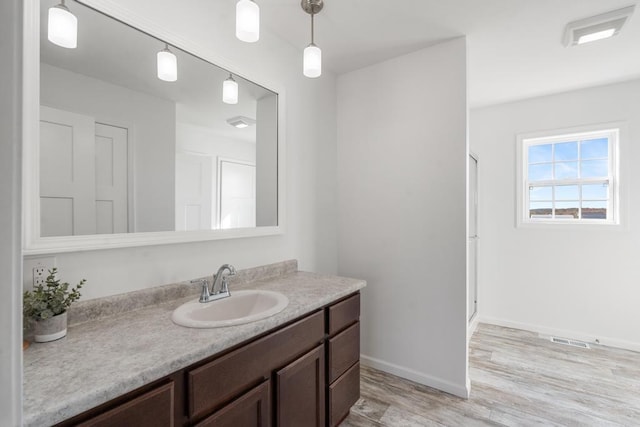 bathroom with wood-type flooring, vanity, and a shower with door