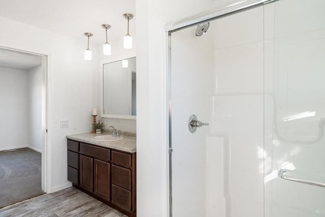 bathroom featuring vanity, wood-type flooring, and walk in shower