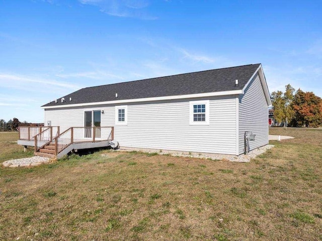 rear view of property featuring a lawn and a wooden deck