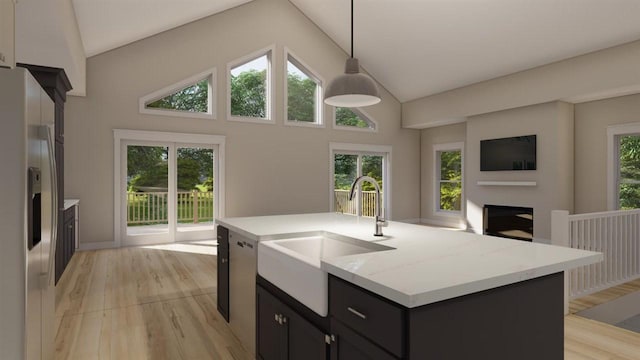 kitchen with a healthy amount of sunlight, sink, an island with sink, and pendant lighting