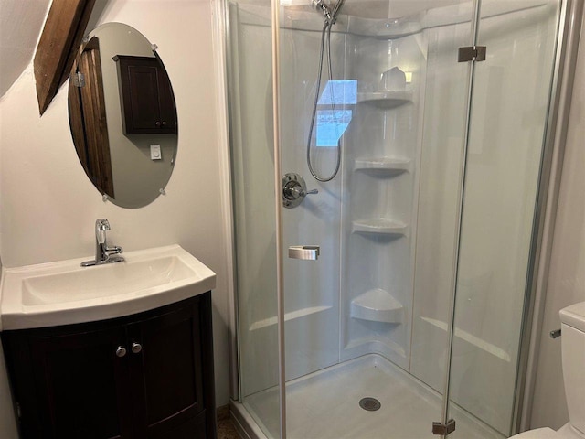 bathroom featuring vanity, toilet, and a shower with door