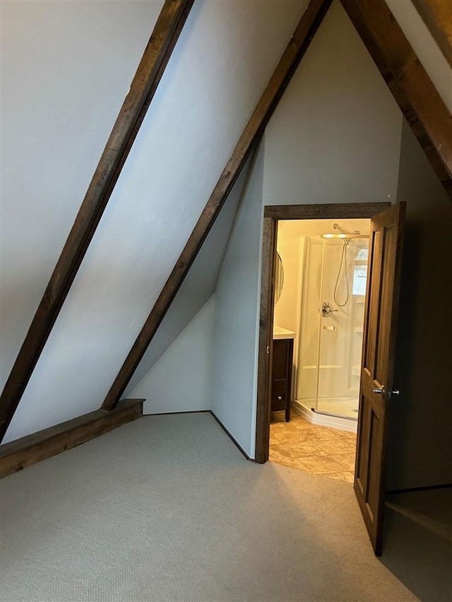 additional living space with vaulted ceiling with beams and light carpet