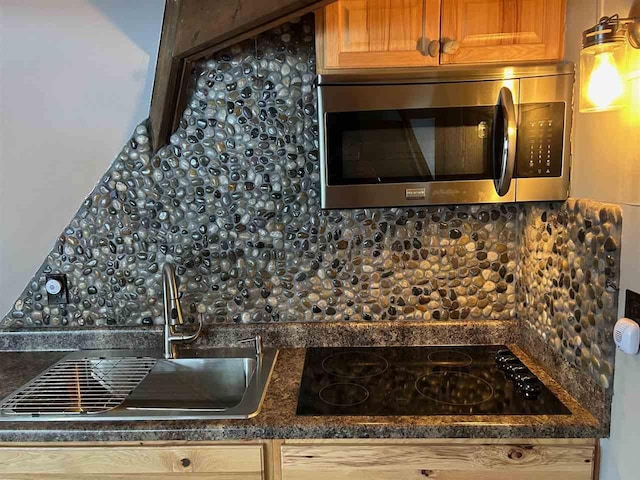 kitchen featuring decorative backsplash, black electric cooktop, and sink